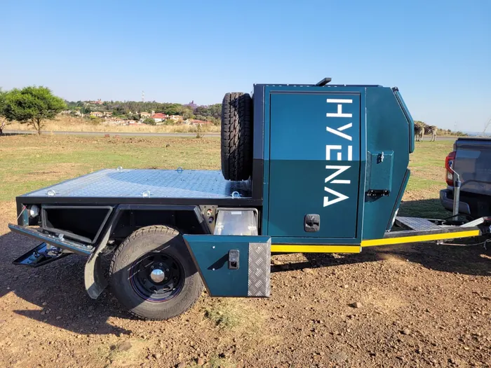 Hyena S1 flatbed side view with storage compartment open and HYENA branding
